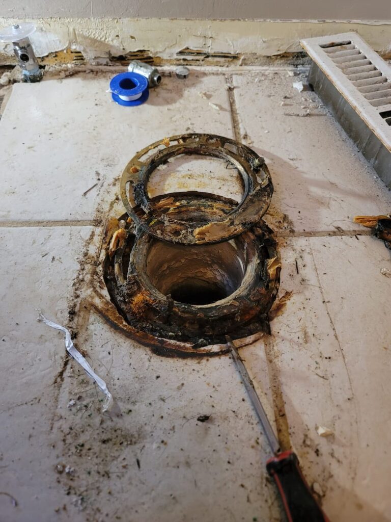 Broken and corroded toilet drain