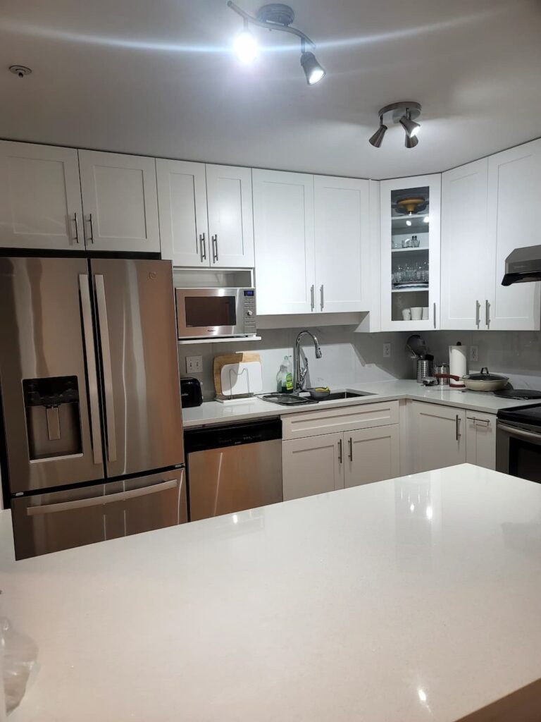 Renovated kitchen with white cabinets and appliances