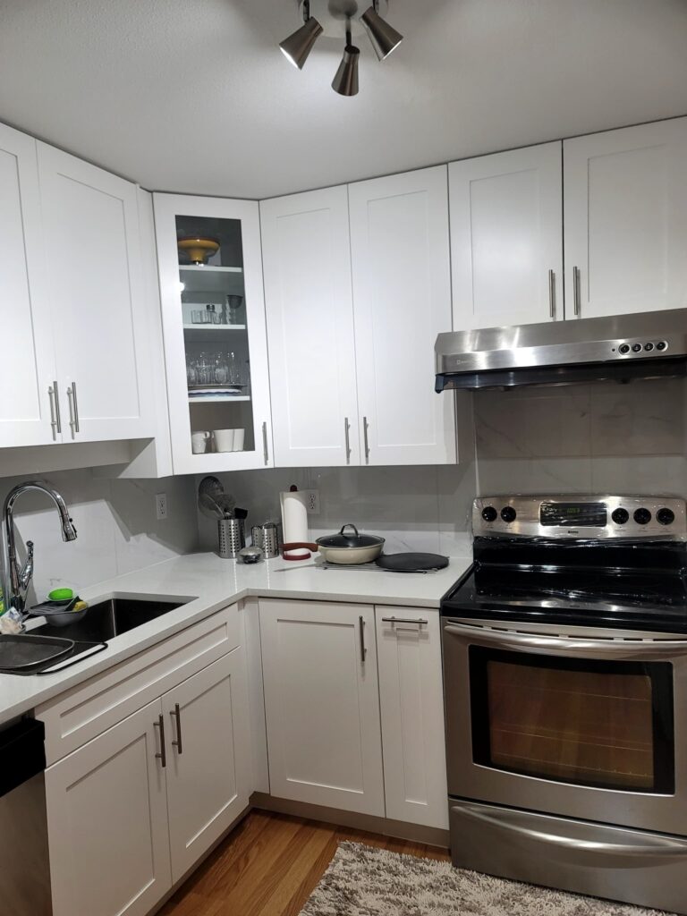 Renovated kitchen with white cabinets and appliances